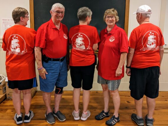 5 board members modeling the polo and backs of the tshirts